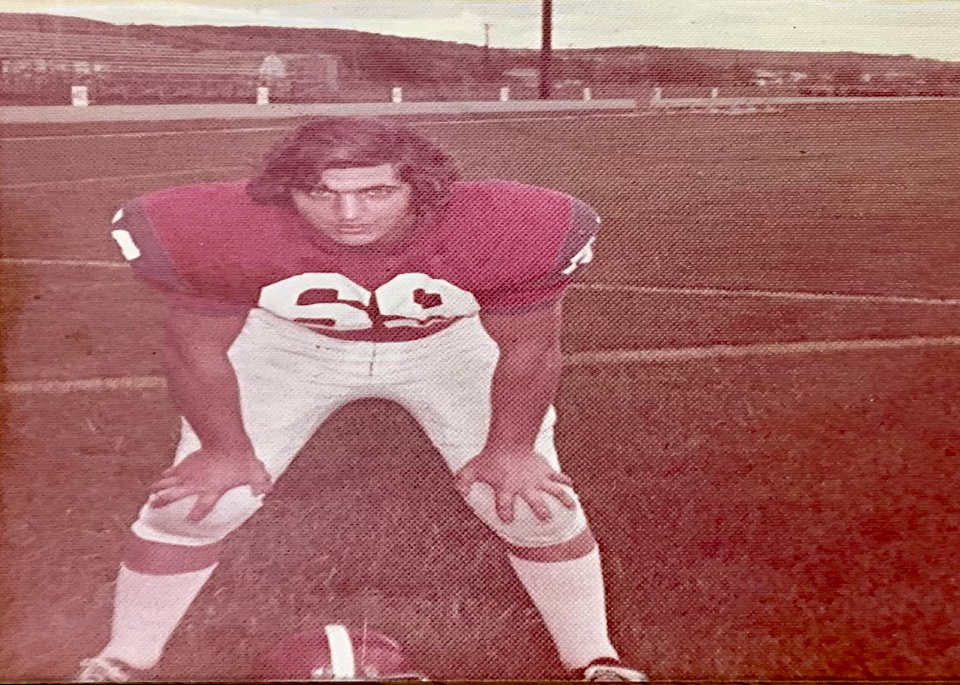 Thomas Rippy in his football uniform posing on a field during his high school sports career